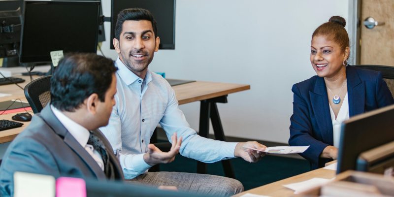 Colleagues engaging in a productive discussion in a modern office setting.