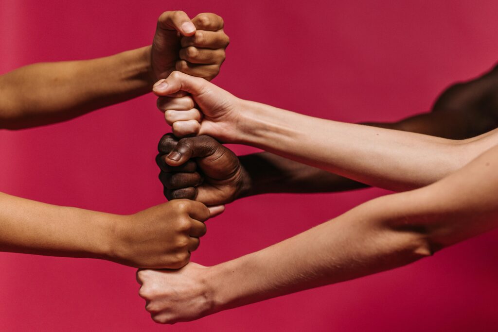 Close-up of diverse hands coming together symbolizing unity and strength.